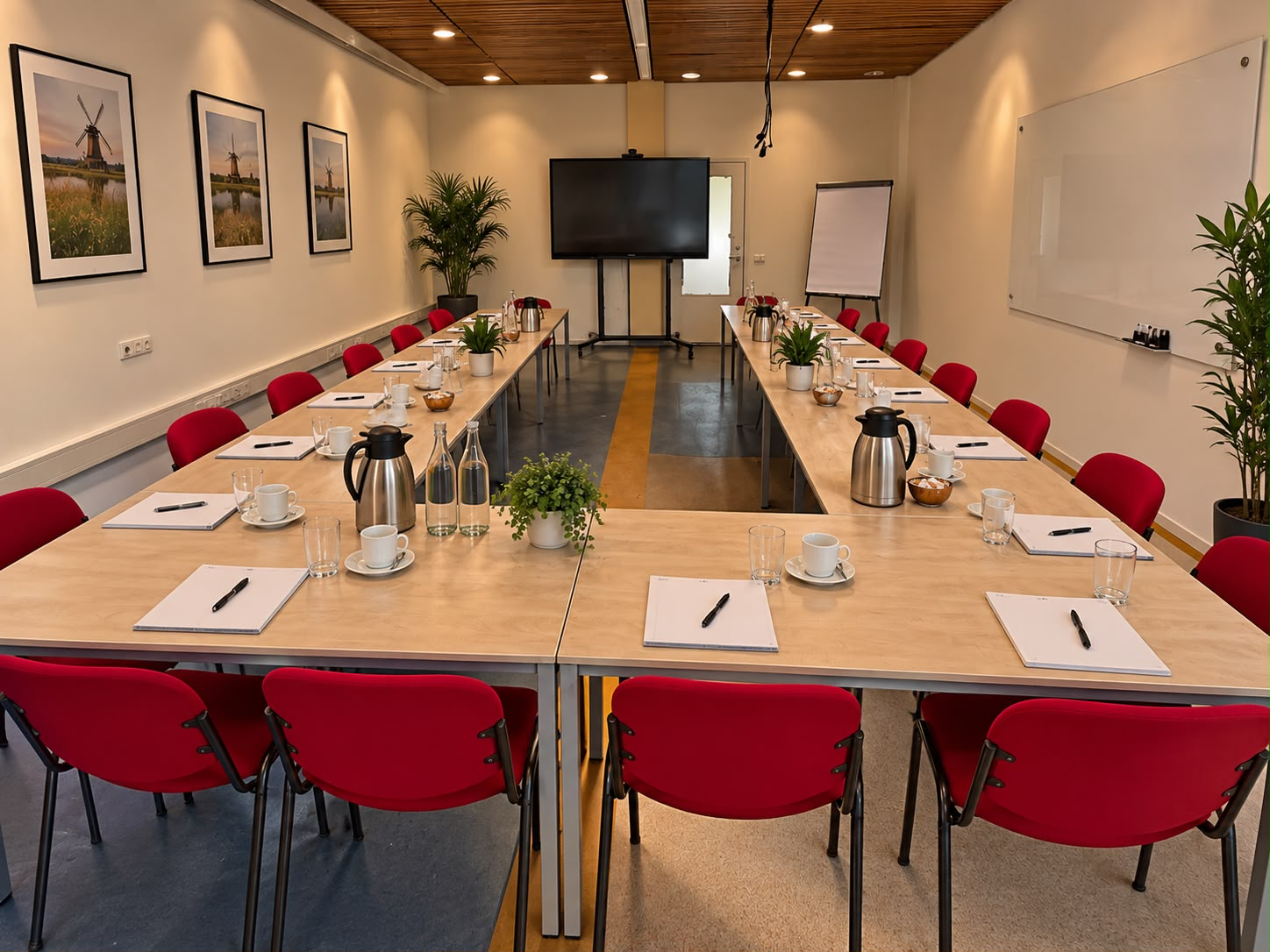 Vergaderruimte met tafels en presentatiescherm